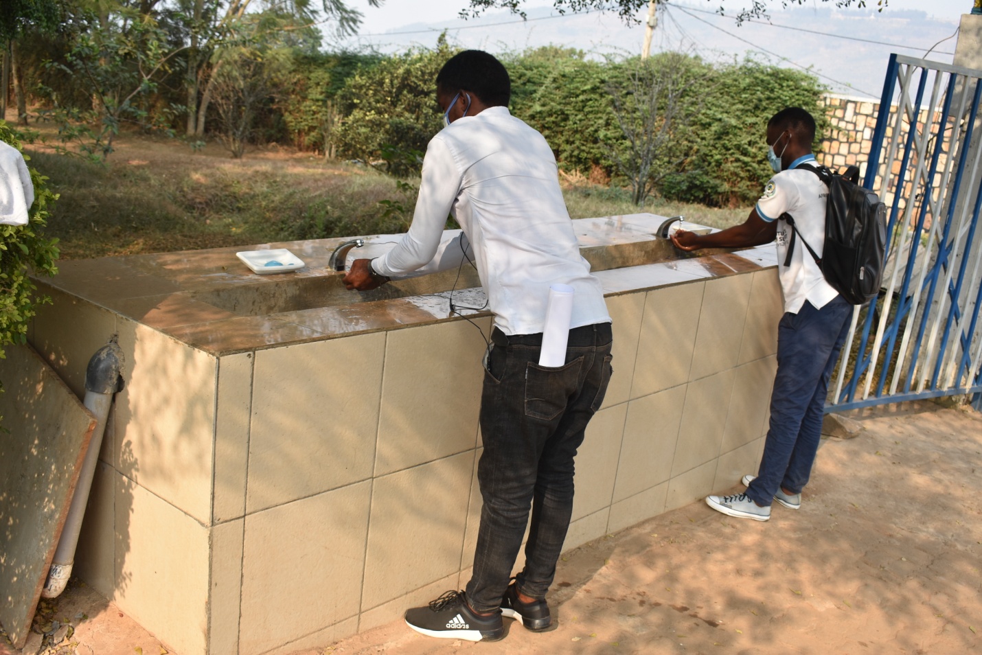 Visitors washing hands at one ULK Hand washing station